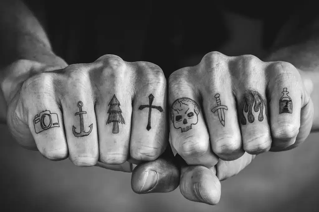 Bold black knuckle tattoos with simple designs that resist finger tattoo fading better than fine line work